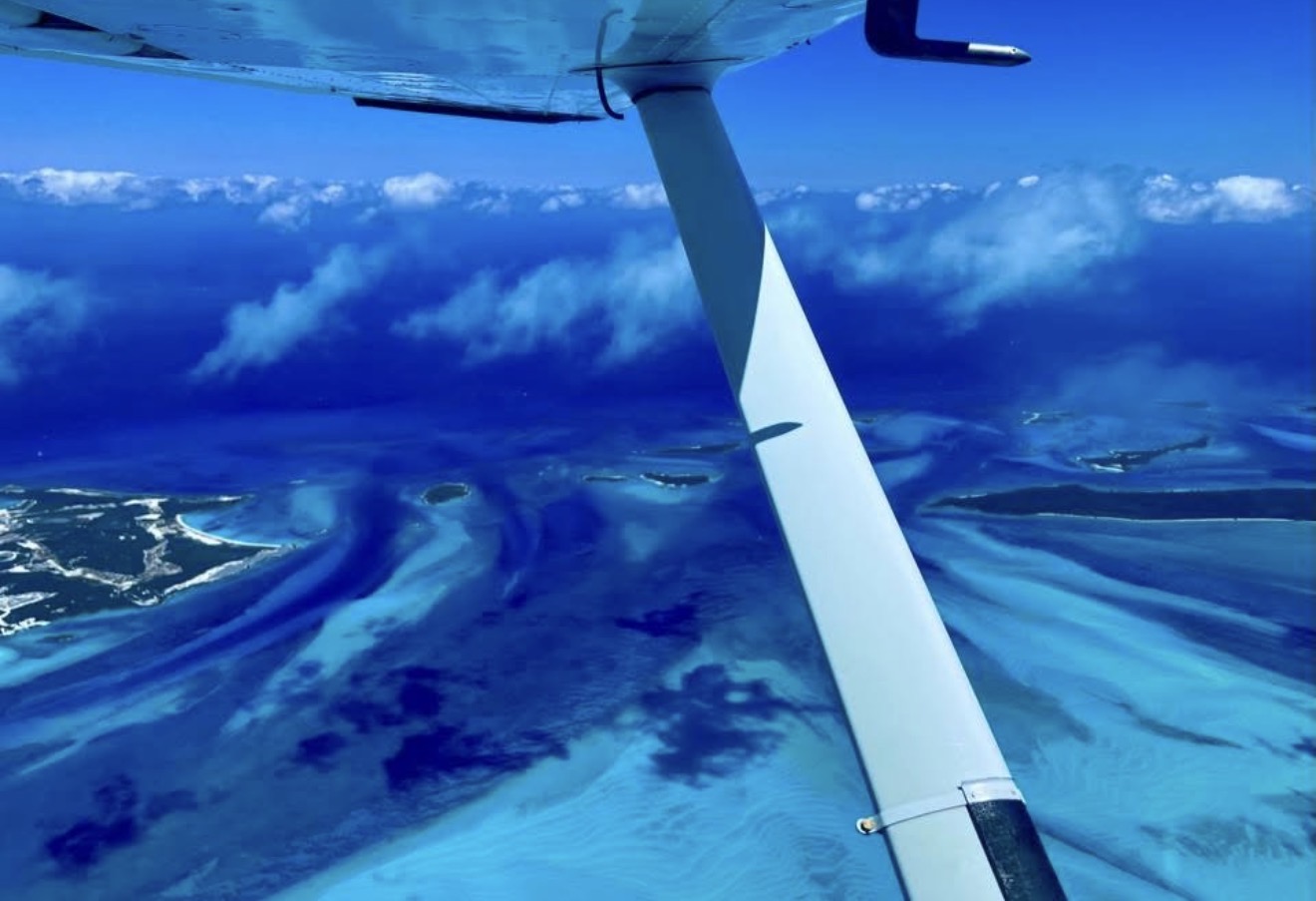Aerial view of turquoise Bahamian islands from a Cessna wing