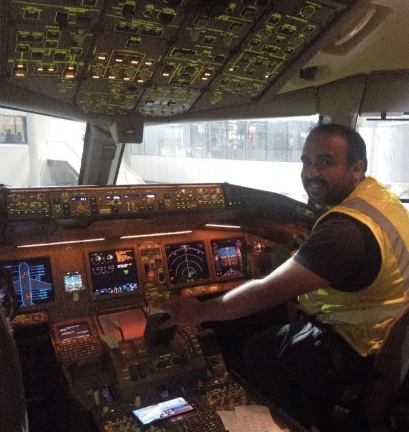Pilot smiling in the flight deck of a wide-body airliner