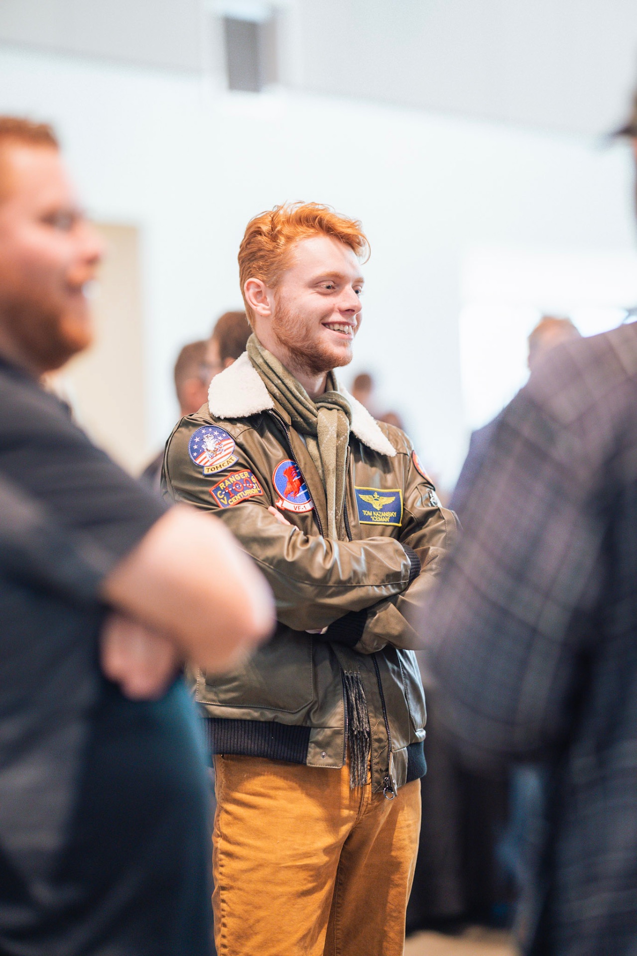 Young man in a vintage flight jacket smiling at a Faith In Flight gathering