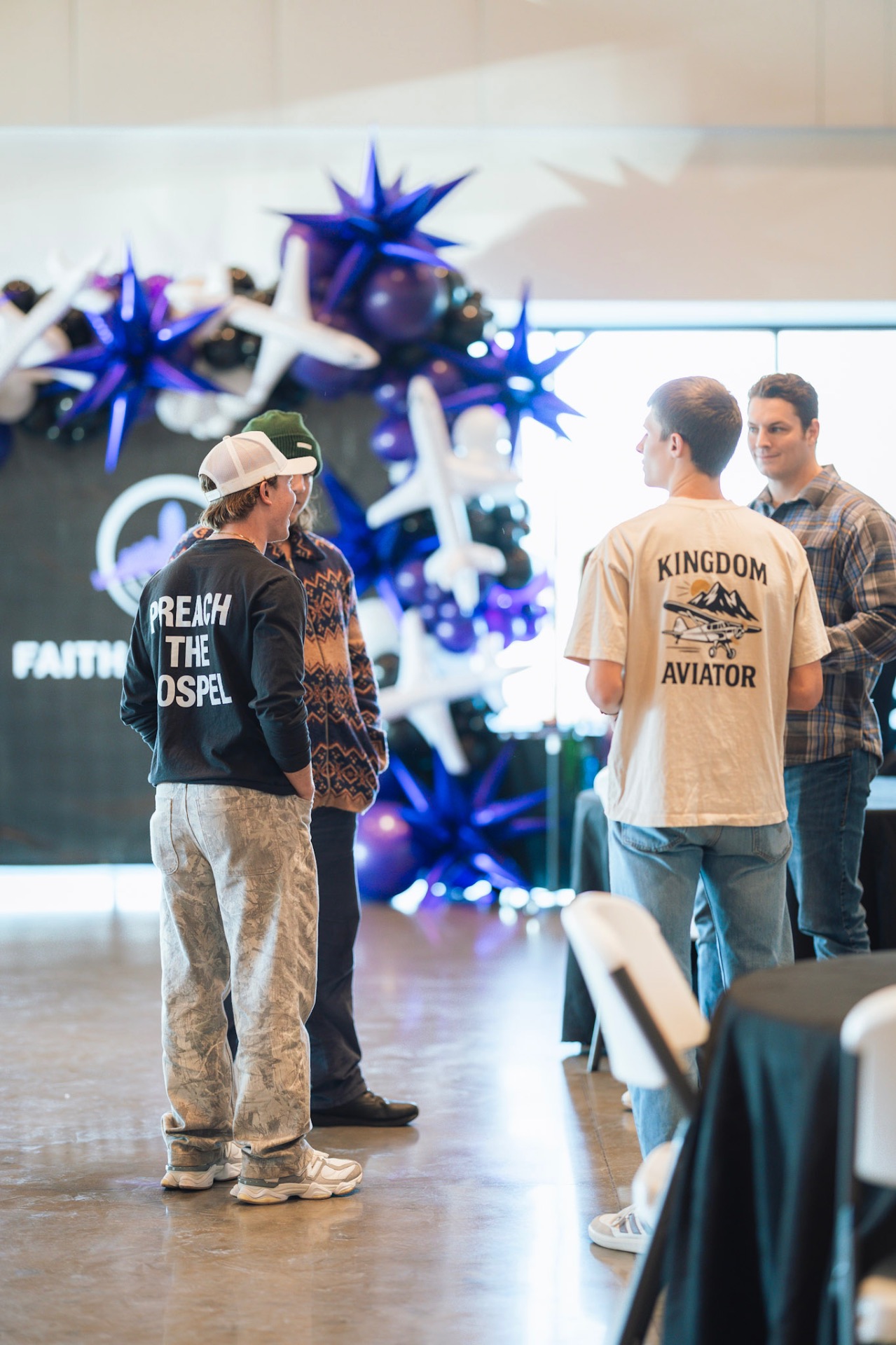 Attendees in conversation in front of the Faith In Flight aviation balloon display